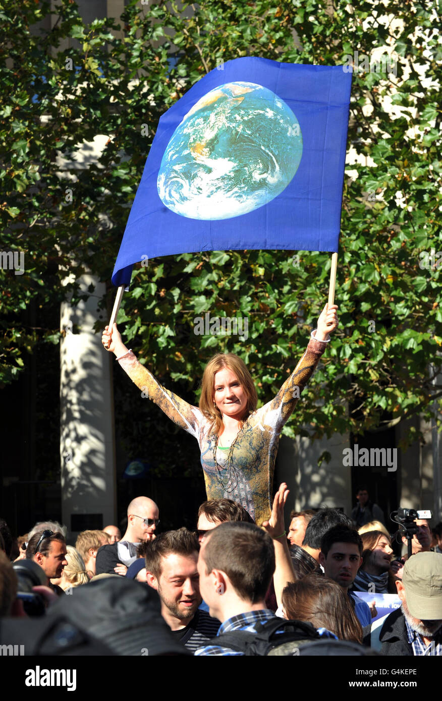 Una donna ha una bandiera durante una protesta contro il sistema finanziario globale, fuori dalla cattedrale di St Paul's, Londra. Foto Stock