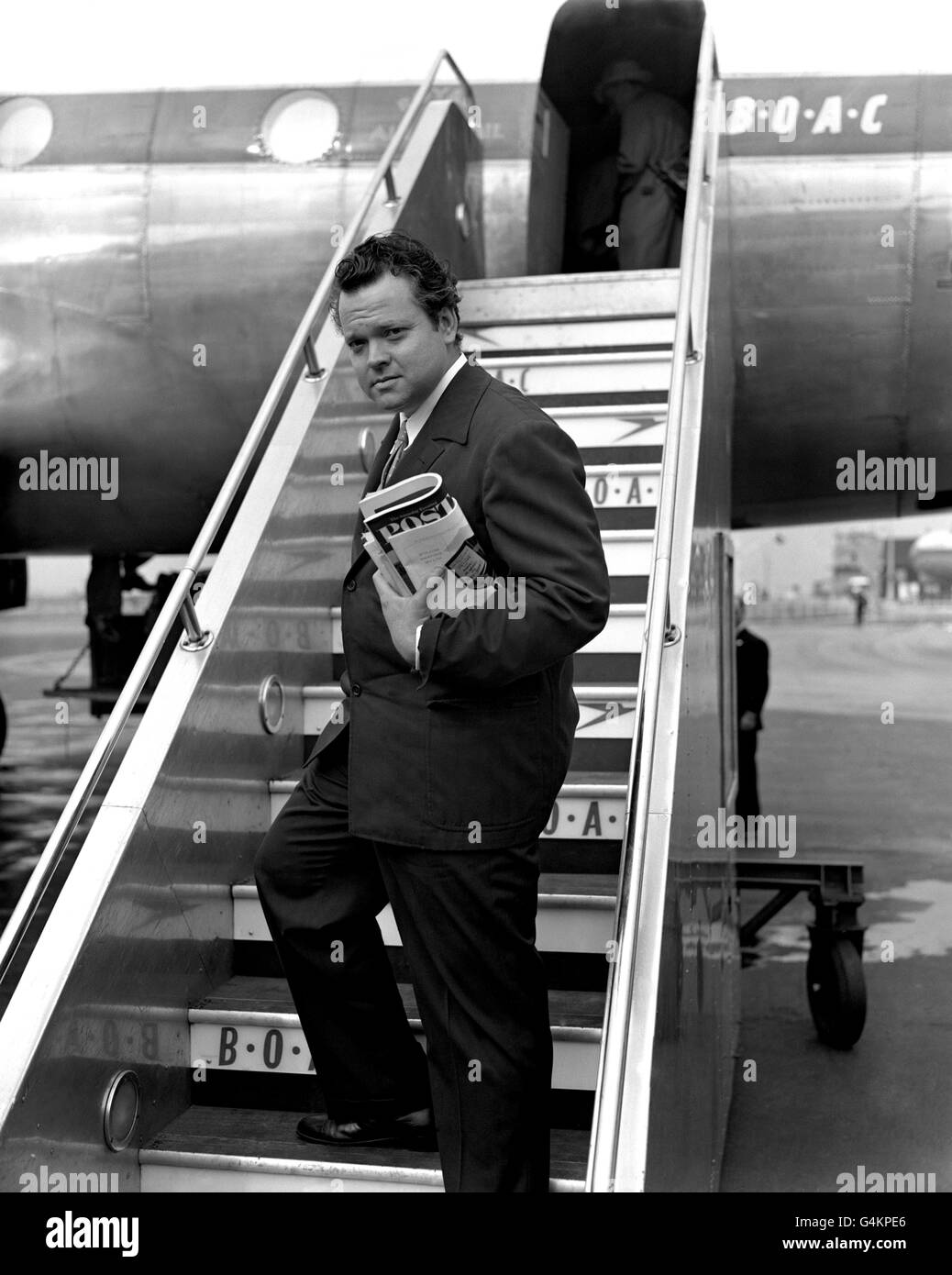 Orson Welles, autore, attore e produttore americano, lascia l'aeroporto di Londra per Roma. Foto Stock