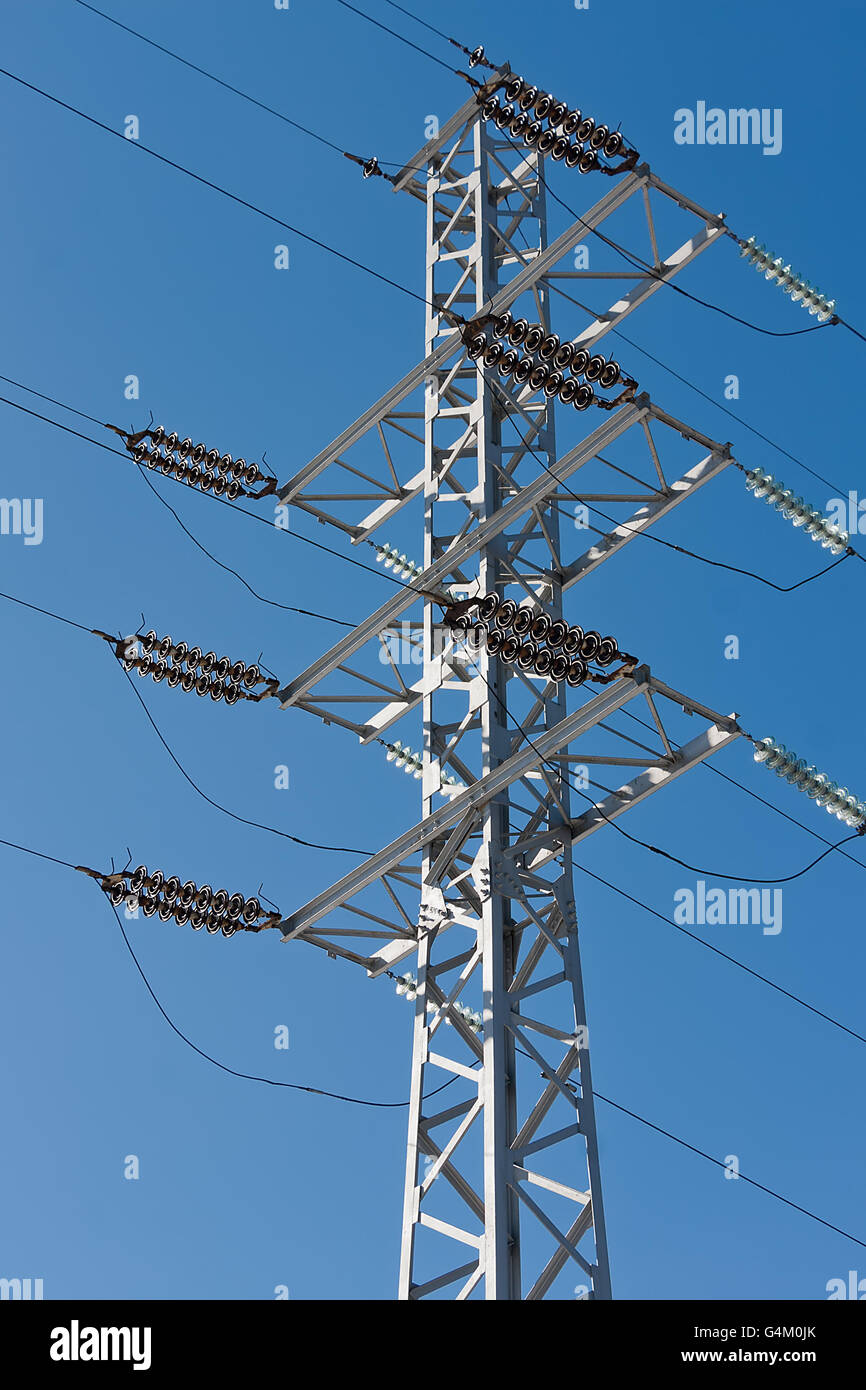 Le linee elettriche di alimentazione su un cielo blu sullo sfondo Foto Stock