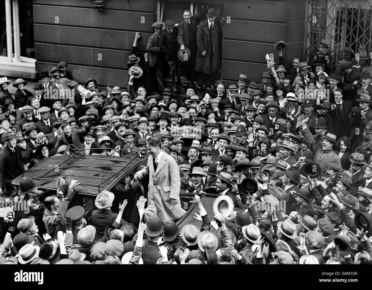 Charlie Chaplin, la star inglese dello schermo silenziosa, si rivolge a una folla enorme fuori dal Ritz Hotel di Londra. Foto Stock