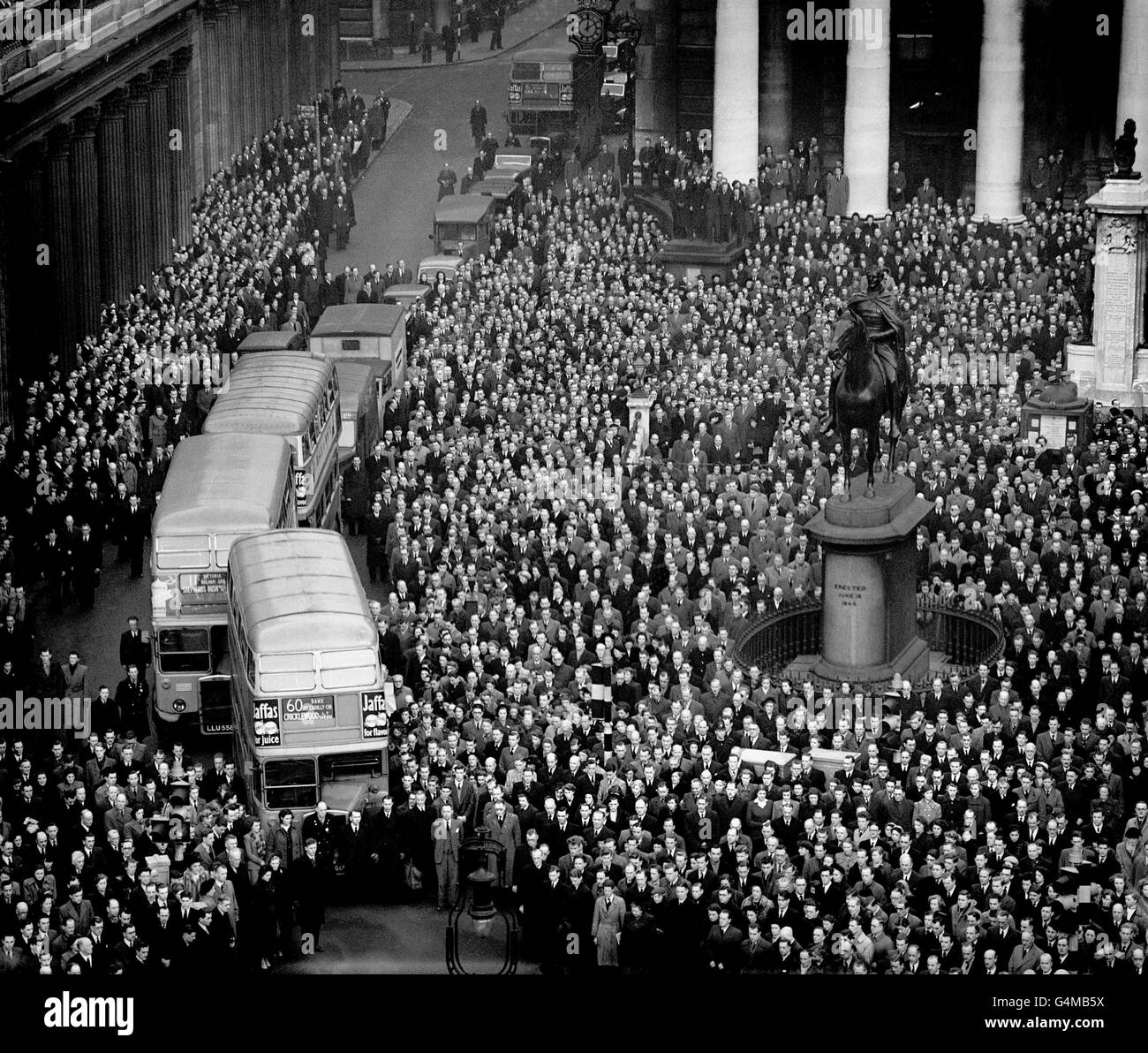 Parte di una folla enorme di persone - molti dei quali lavoratori della City of London - si sono riuniti al Royal Exchange per rendere un ultimo muto omaggio alla memoria di re Giorgio VI Foto Stock