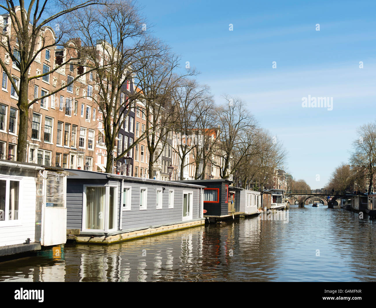 Una vista lungo uno di Amsterdam i tanti canali in una bella giornata di primavera. Foto Stock
