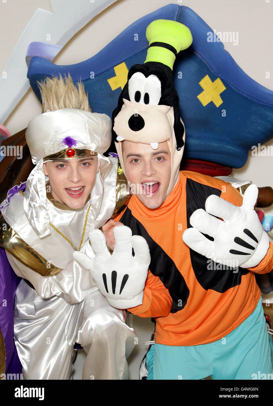 Jedward si veste come Goofy e Aladdin ad Hamleys nel centro di Londra per il lancio del gioco di Disney Universe. Foto Stock