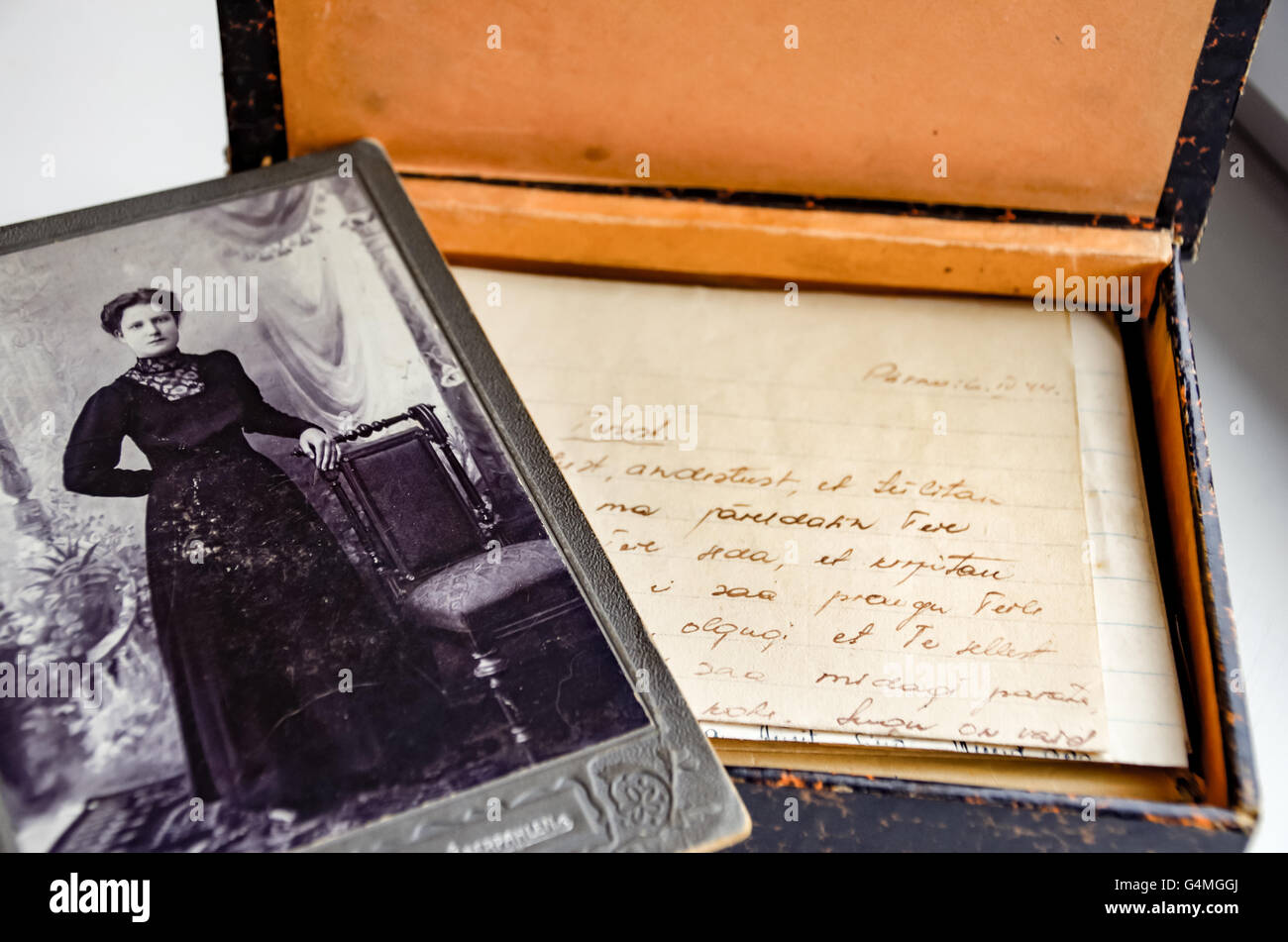 Antica b&w ritratto di una donna nel periodo vestito con una scatola di ingiallito lettere d'amore da 1944, trovati in un attico Foto Stock