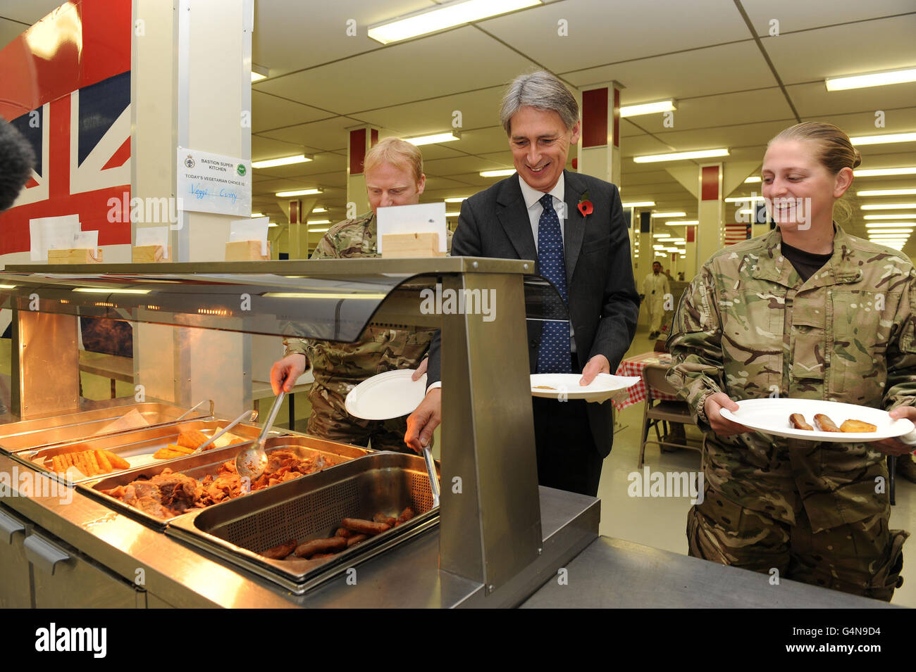 Il Segretario della Difesa Philip Hammond nel NAAFI al Camp Bastion durante la sua visita in Afghanistan per incontrare le truppe e partecipare ad una speciale Parata dell'armistizio nel 93° anniversario della fine della prima guerra mondiale. Foto Stock