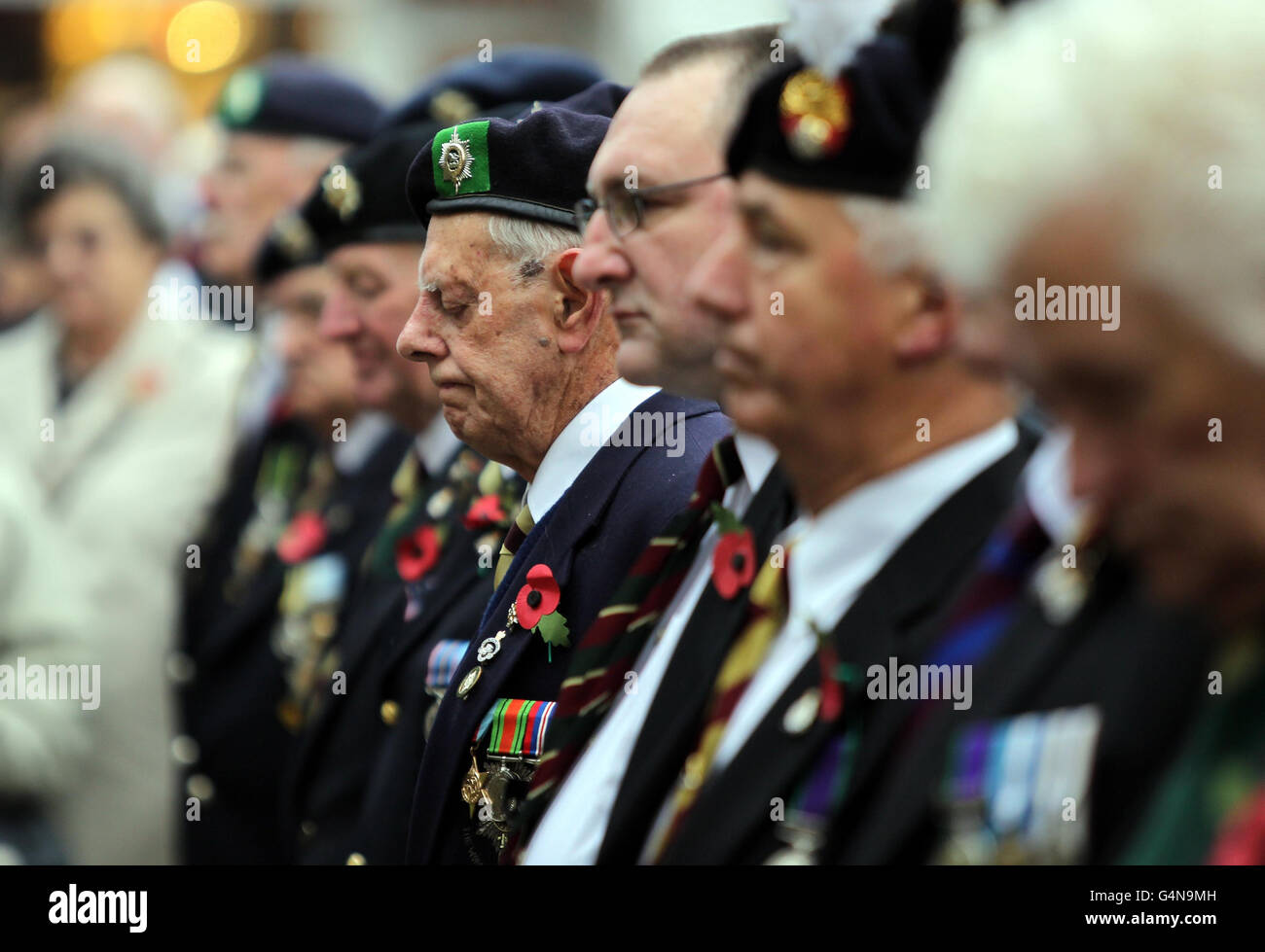 Gli ex militari osservano i due minuti di silenzio ad un servizio di giorno di Armistice fuori della cattedrale di Worcester, Worcester. Foto Stock