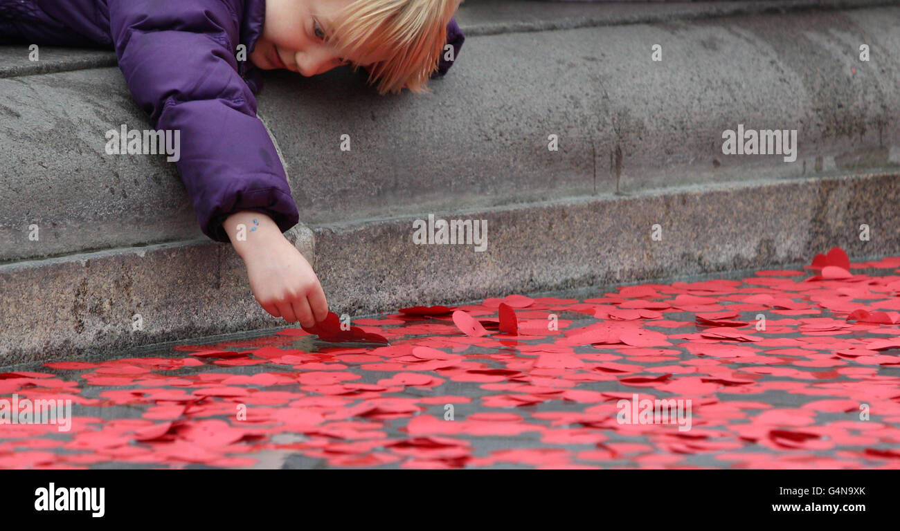 I papaveri sono collocati nelle fontane di Trafalgar Square, Londra, per segnare il giorno dell'Armistice. Foto Stock