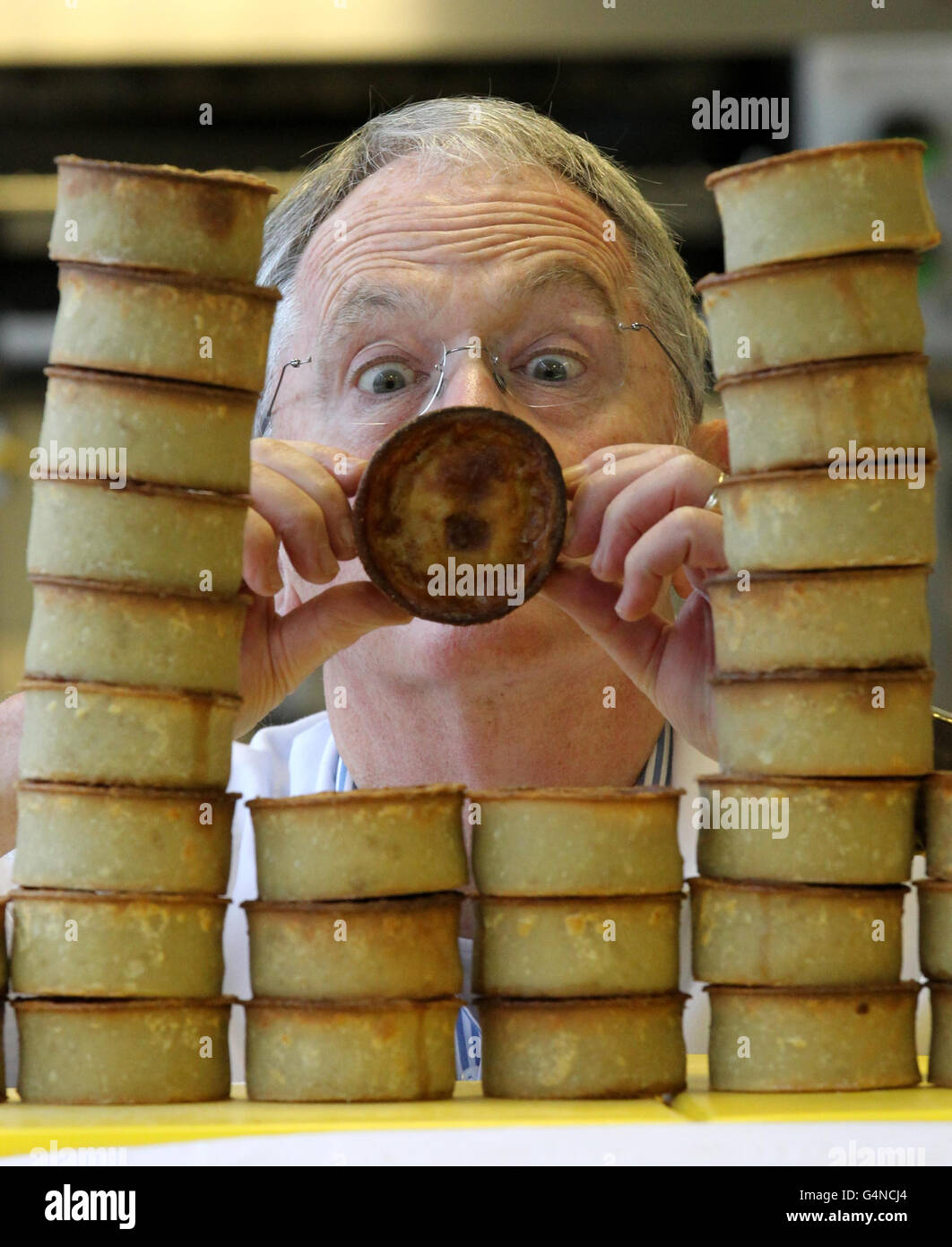 Il giudice capo Robert Ross giudica i pies durante il Campionato del mondo Scotch Pie al Carnegie College di Dunfermline. Foto Stock