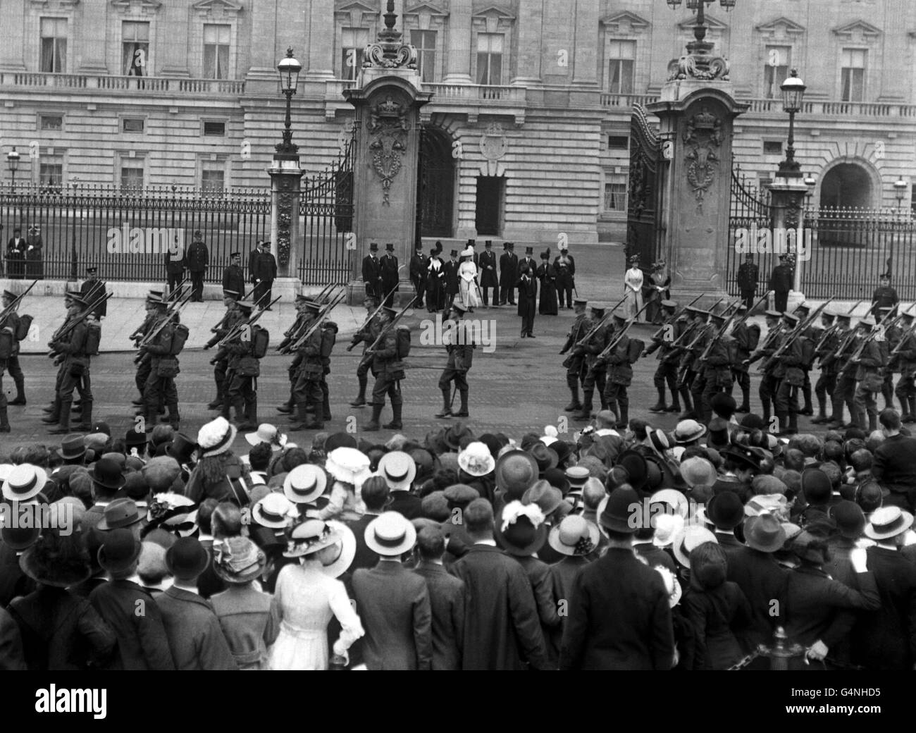 1914: Re George V prende il saluto mentre le prime Guardie passano Buckingham Palace sulla loro strada per la Francia per il servizio attivo all'inizio della prima guerra mondiale. Foto Stock