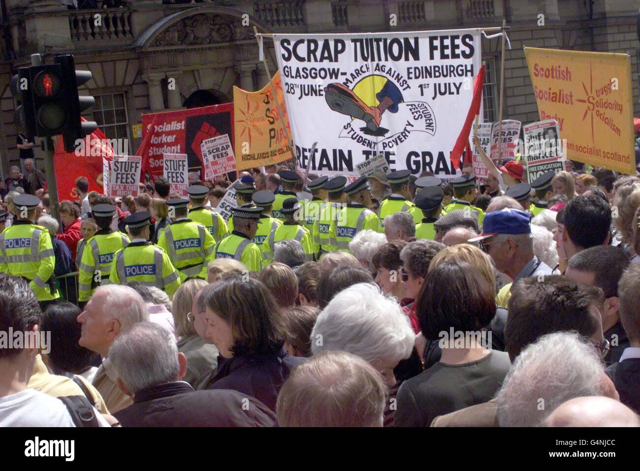 Una manifestazione del Partito socialista viene mossa dalla polizia sul Royal Mile mentre la carrozza della Regina si avvicina per l'apertura di Stato del parlamento. Foto Stock