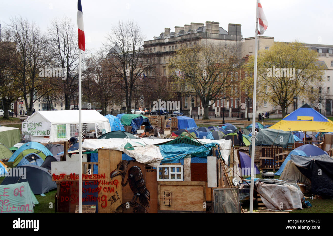 I membri del gruppo Occupy Bristol hanno istituito un campo su College Green nel centro di Bristol. PREMERE ASSOCIAZIONE foto. Data immagine: Sabato 19 novembre 2011. La più grande protesta anti-capitalista fuori Londra continuava oggi con gli attivisti che si rifiutavano di schernire. Tende, baracche di legno e persino una carovana sono apparsi sullo storico College Green nel centro di Bristol. I membri della campagna Occupy Bristol sono stati accampati in tende per poco più di un mese e hanno costruito più strutture permanenti di pallet di legno. L'accampamento da 60 tende si trova sulla terra di proprietà della Cattedrale di Bristol Foto Stock