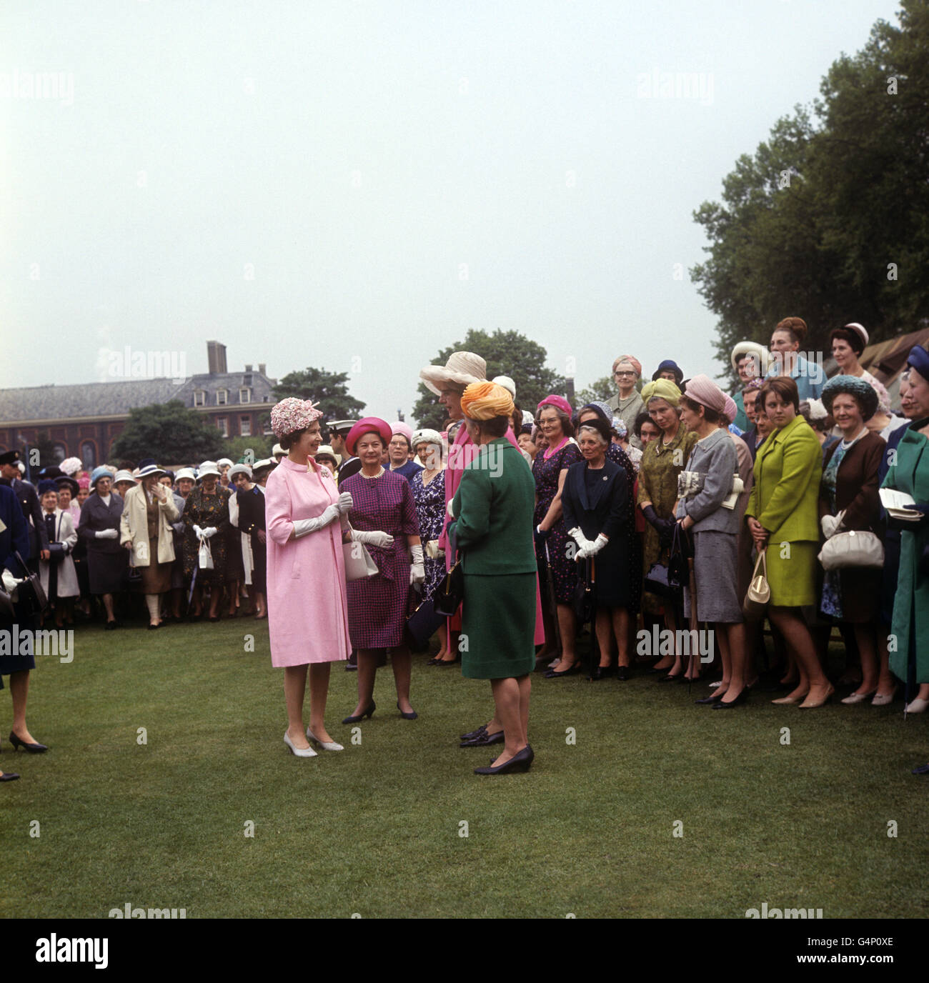 La Regina Elisabetta II parla con gli ospiti di una festa in giardino nel Royal Hospital Grounds, Chelsea, in relazione ai servizi delle donne per il 50° anniversario. Foto Stock