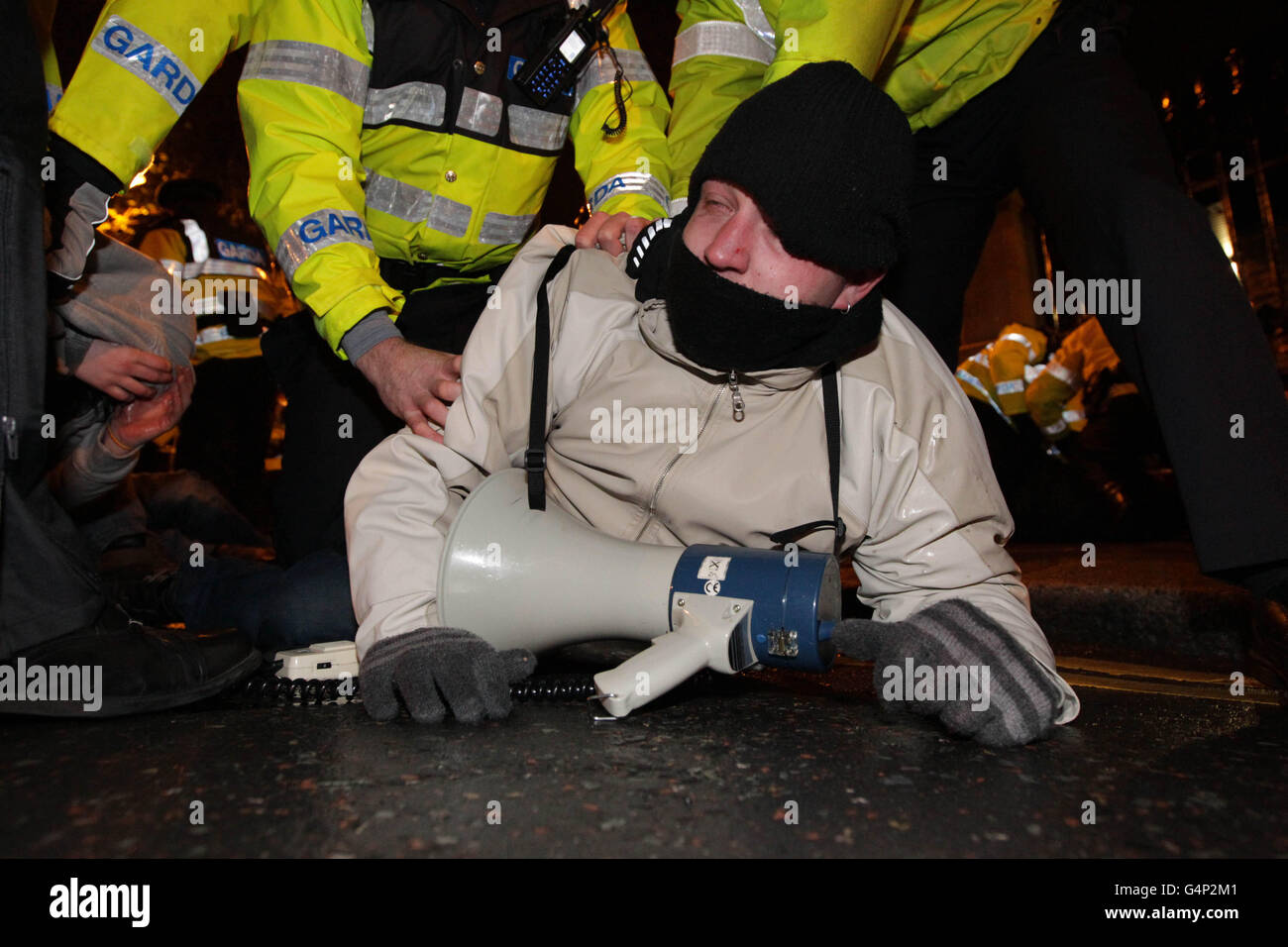 Gardai rimuove i manifestanti anti anti anti austerità che hanno cercato di bloccare le porte della Leinster House a Dublino dopo che il ministro delle finanze Michael Noonan ha consegnato il suo bilancio agli edifici governativi, durante il secondo giorno del bilancio irlandese. Foto Stock