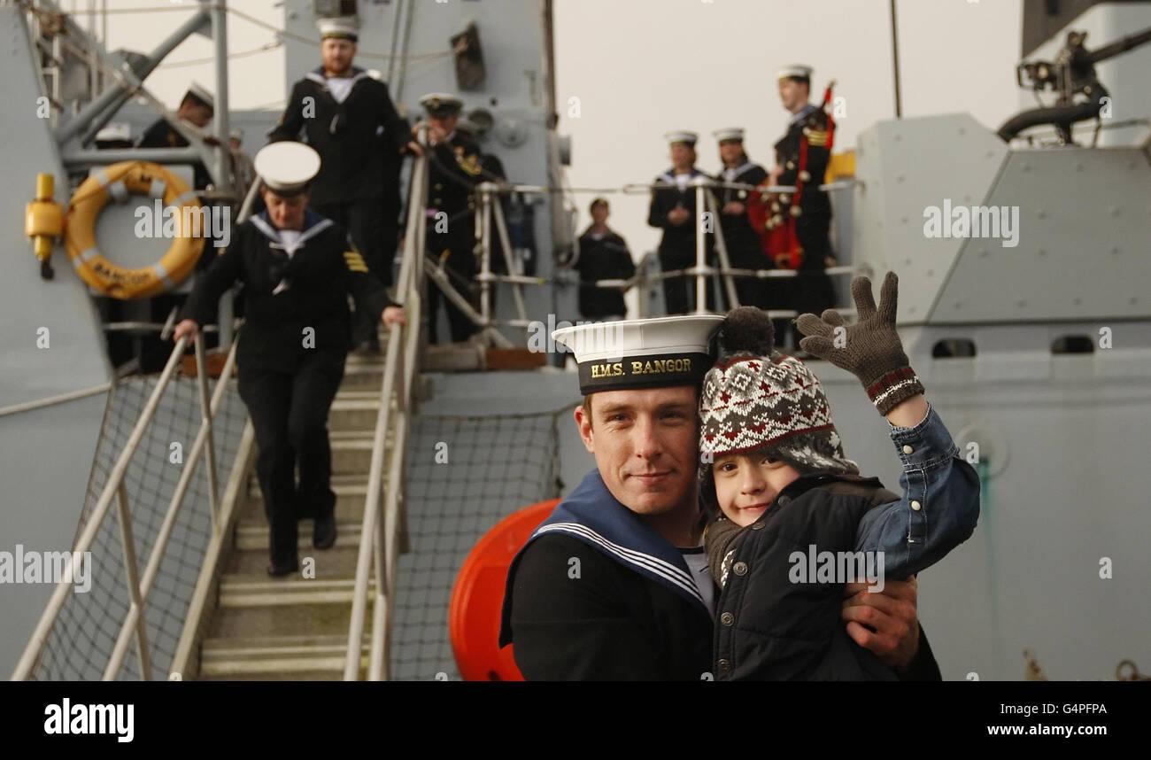 Il marinaio abile Will Owen è accolto dal nipote George Owen, 7 anni, mentre disembra HMS Bangor alla base navale di HM Clyde in Scozia. Foto Stock