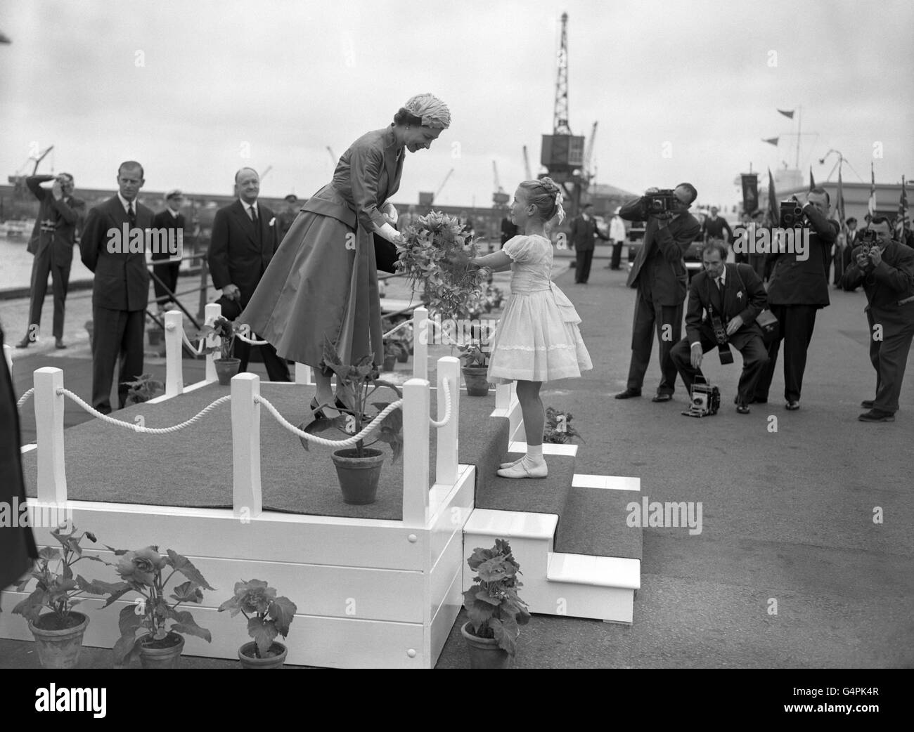 Melodie Brown, di nove anni, presenta fiori alla Regina dopo che è atterrata dal Royal Yacht Britannia a St. Aubin's Bay, Jersey, per iniziare il loro tour delle Isole del canale. Foto Stock
