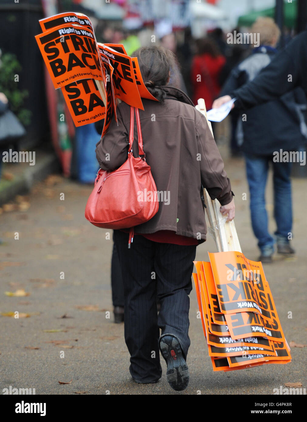 Un membro del pubblico porta cartelli prima di una marcia da parte dei lavoratori del settore pubblico nel centro di Londra, mentre i lavoratori di tutto il Regno Unito sono oggi in fila per decenni il più grande sciopero generale sulle pensioni. Foto Stock