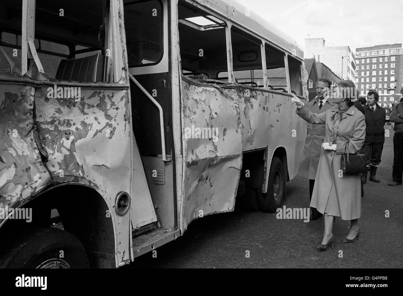 Il primo ministro Margaret Thatcher guardando il pullman dell'esercito, il suo lato male ammaccato e con le unghie incastonate nella carrozzeria, a Ebury Bridge Road, Londra, quando ha visitato la scena di un attacco di una bomba a unghie vicino a Chelsea caserma. Una donna è morta durante l'esplosione e 38, molti di loro soldati sono stati feriti. Foto Stock