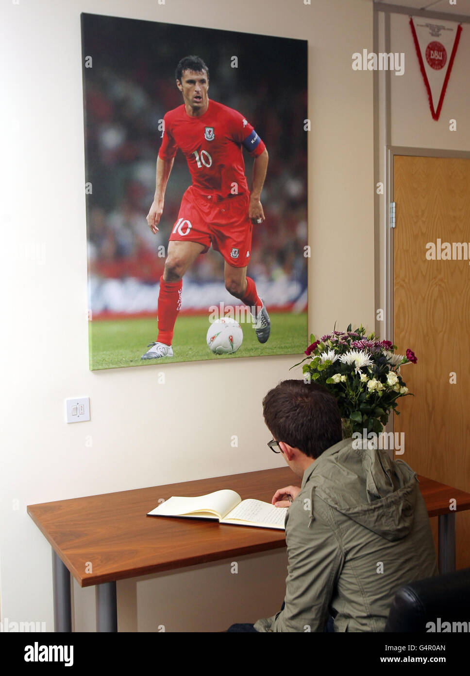 Calcio - Tribute Gary Speed. Un fan firma il libro di ricordi per Gary Speed all'interno della Welsh Football Association ofiices, Cardiff. Foto Stock Calcio - Tribute Gary Speed. Un fan firma il libro di ricordi per Gary Speed all'interno della Welsh Football Association ofiices, Cardiff. Foto Stock