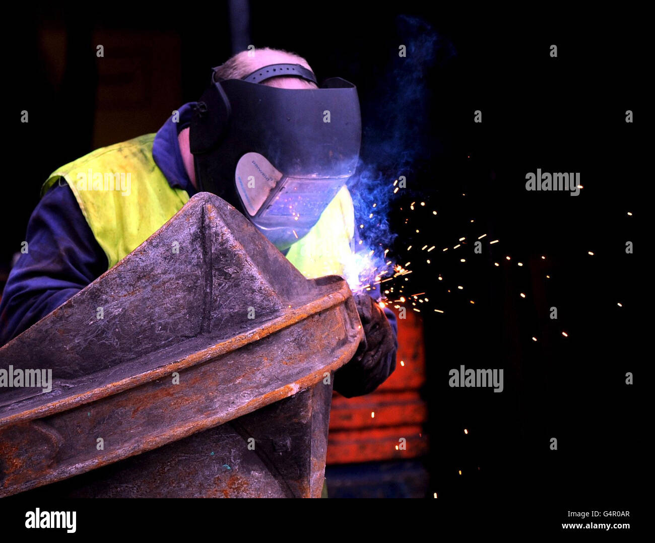 Un uomo lavora in un deposito di rottami a Bradford, in vista della dichiarazione autunnale rilasciata domani dal Cancelliere dello scacchiere George Osborne, quando delineerà lo stato dell’economia britannica. Foto Stock