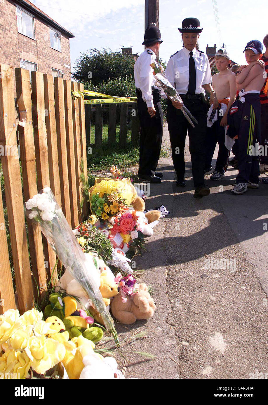 Un Policewoman depone fiori alla proprietà di Calvert Terrace, Murton, dove il corpo di una giovane ragazza creduto essere quello di mancante nove anni Laura Kane è stato scoperto. Foto Stock