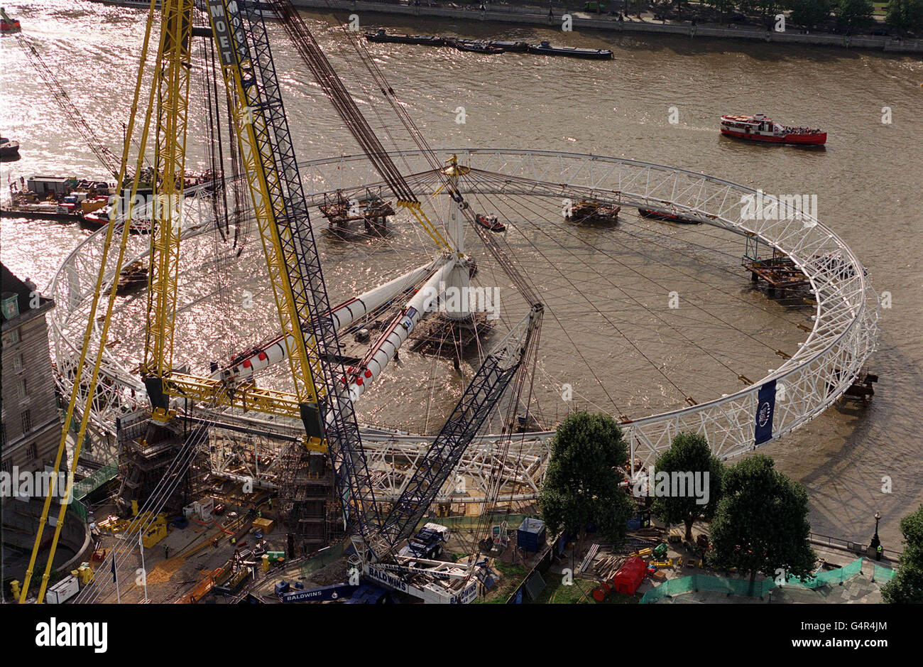 Il British Airways London Eye, la ruota panoramica più grande del mondo, si trova sul lato del Tamigi di Londra. La ruota dovrebbe essere sollevata in luogo da County Hall, più tardi. Foto Stock