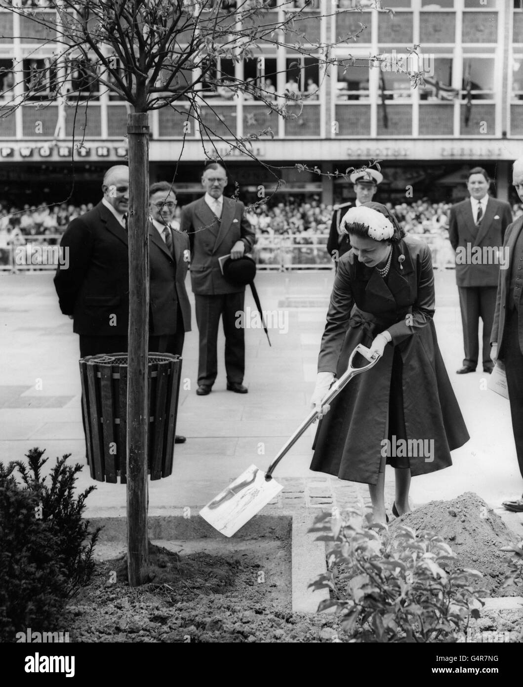 La Regina Elisabetta II pianta un albero di granchio in Piazza della Regina, durante la sua visita alla nuova città di Crawley, Sussex. Foto Stock