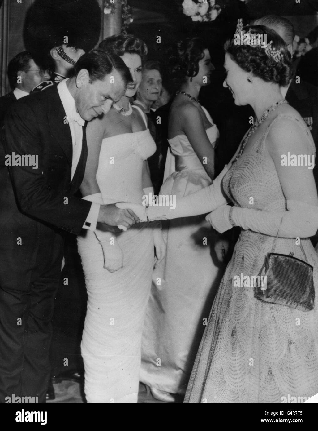 Il cantante e attore americano Frank Sinatra è presentato alla regina Elisabetta II nel foyer dell'Odeon Theatre, Leicester Square, Londra, alla prima del film di Danny Kaye, 'e il colonnello' Foto Stock