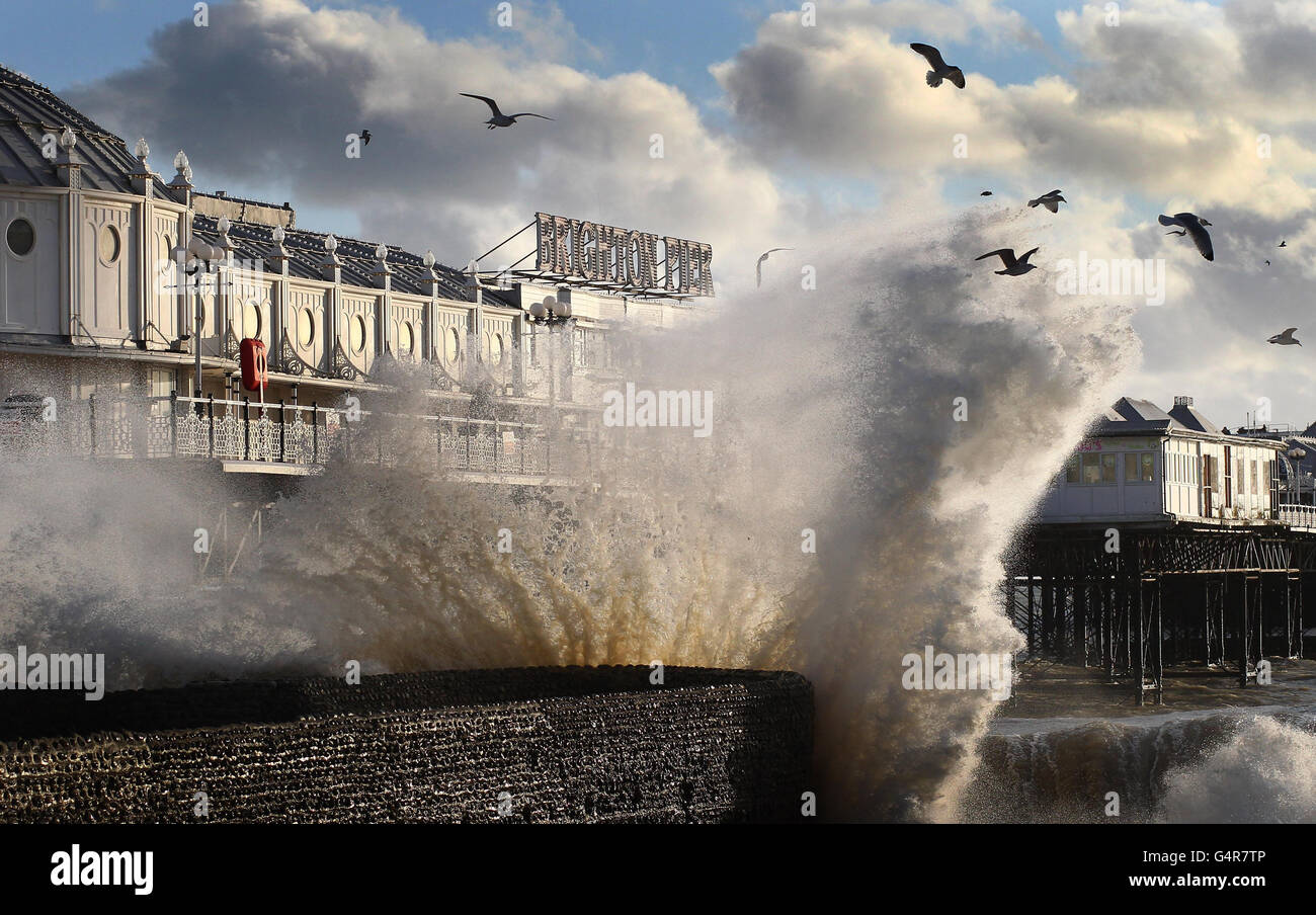 Le onde si infrangono sul lungomare vicino al molo di Brighton nel Sussex orientale. La Gran Bretagna continuerà a tremare in condizioni di ghiaccio con venti alti e previsioni di neve più per le parti del paese, ha detto i previsori. Foto Stock