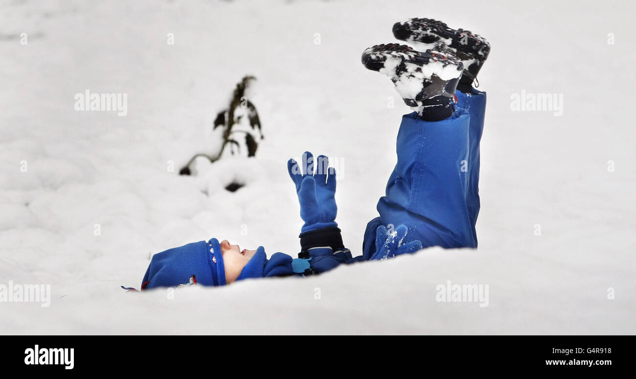 Ethan Woodley, di due anni, ama giocare sulla neve a Whitburn, in Scozia, a seguito delle fresche cadute di neve durante la notte. Foto Stock