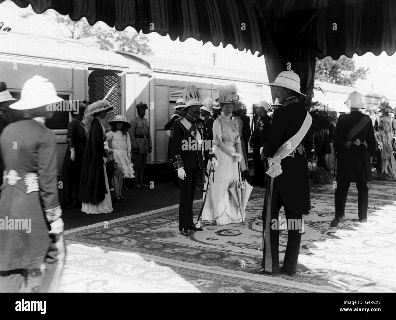 Re Giorgio V e la Regina Maria con dignitari britannici presso una stazione ferroviaria in India durante il tour di Delhi Durbar. Foto Stock