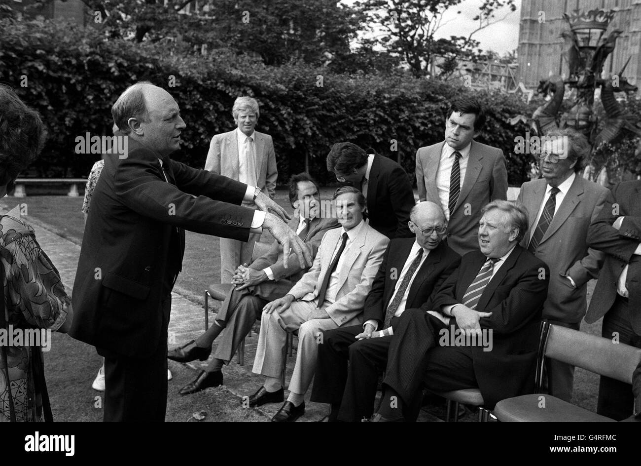 Il leader del lavoro Neil Kinnock fa il suo Tommy Cooper agire come egli chiede l'ordine dal suo nuovo gabinetto ombra che si prepara per la fotocellula di oggi fuori della Camera del Parlamento. Seduti nella parte anteriore sono a sinistra: Dr. John Cunningham, Derek Foster, Gerald Kaufman e Roy Hattersley. In piedi da sinistra: Bryan Davies, Secretriy del Partito laburista parlamentare, Jack Straw, Gordon Brown e Lord Cledwyn Foto Stock