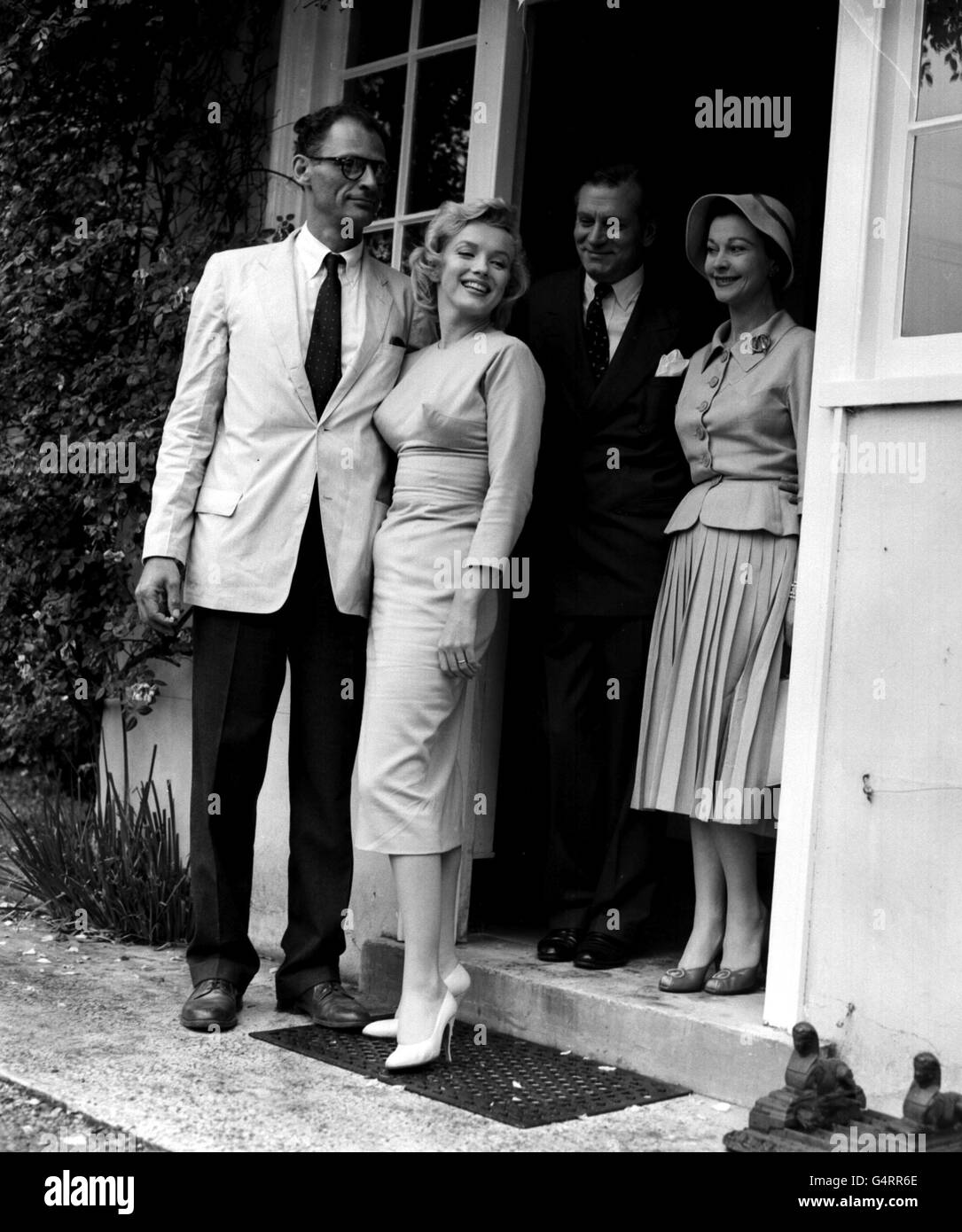 Marilyn Monroe, con suo marito Arthur Miller, Sir Laurence e Lady Olivier dietro di loro, a Parkfield House, Englefield Green, Surrey, dove hanno soggiornato durante la loro visita. Monroe era lì per fare il film 'il Principe addormentato' con Sir Laurence a Pinewood. Foto Stock