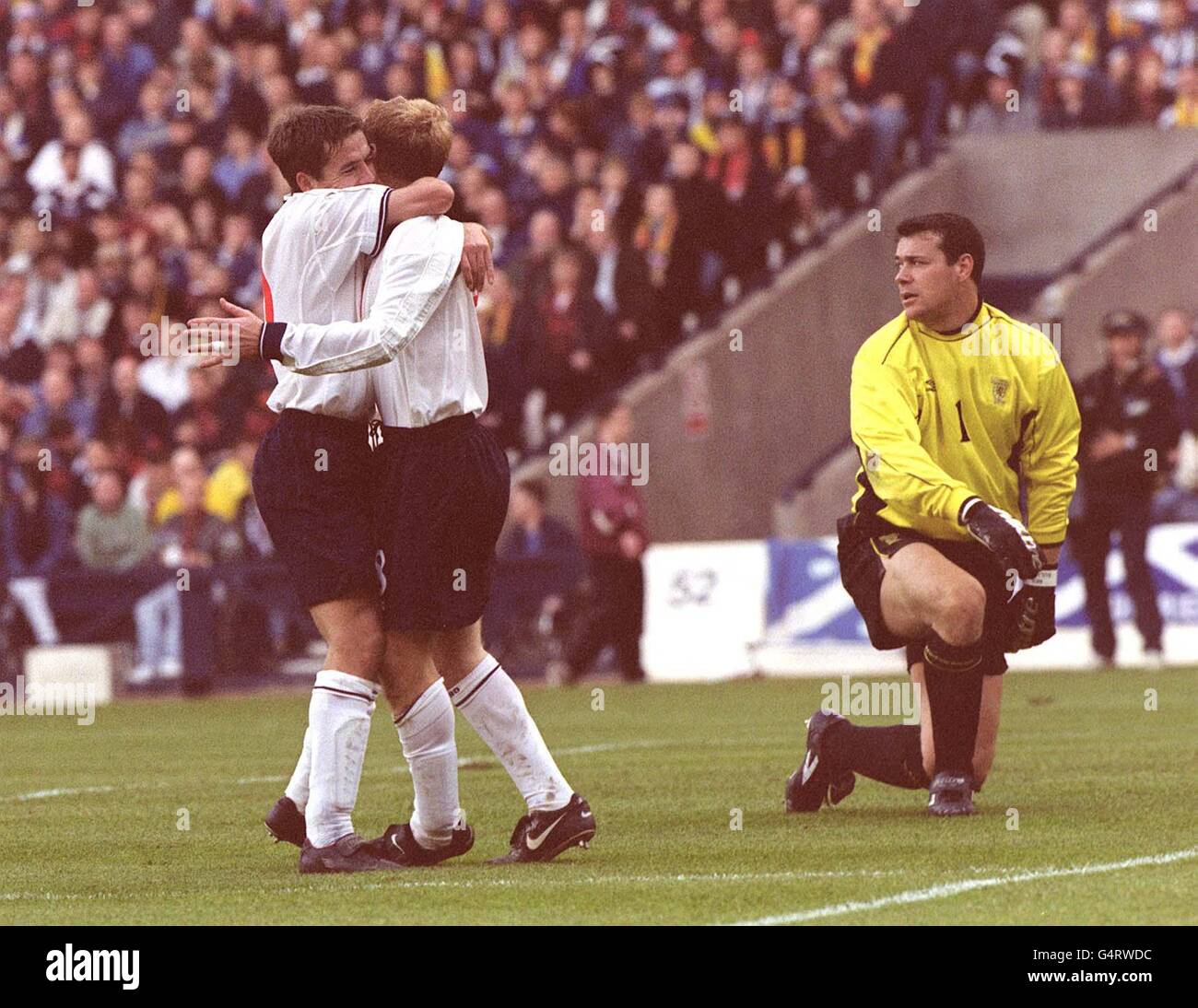 Inghilterra Joy e Scozia disperano come Michael Owen (L) si congratula con Paul Scholes dopo aver segnato il suo secondo gol durante la partita di calcio Euro 2000 all'Hampden Park. * Punteggio finale: Scozia 0 Inghilterra 2. * mentre il portiere Neil Sullivan guarda. Foto Stock