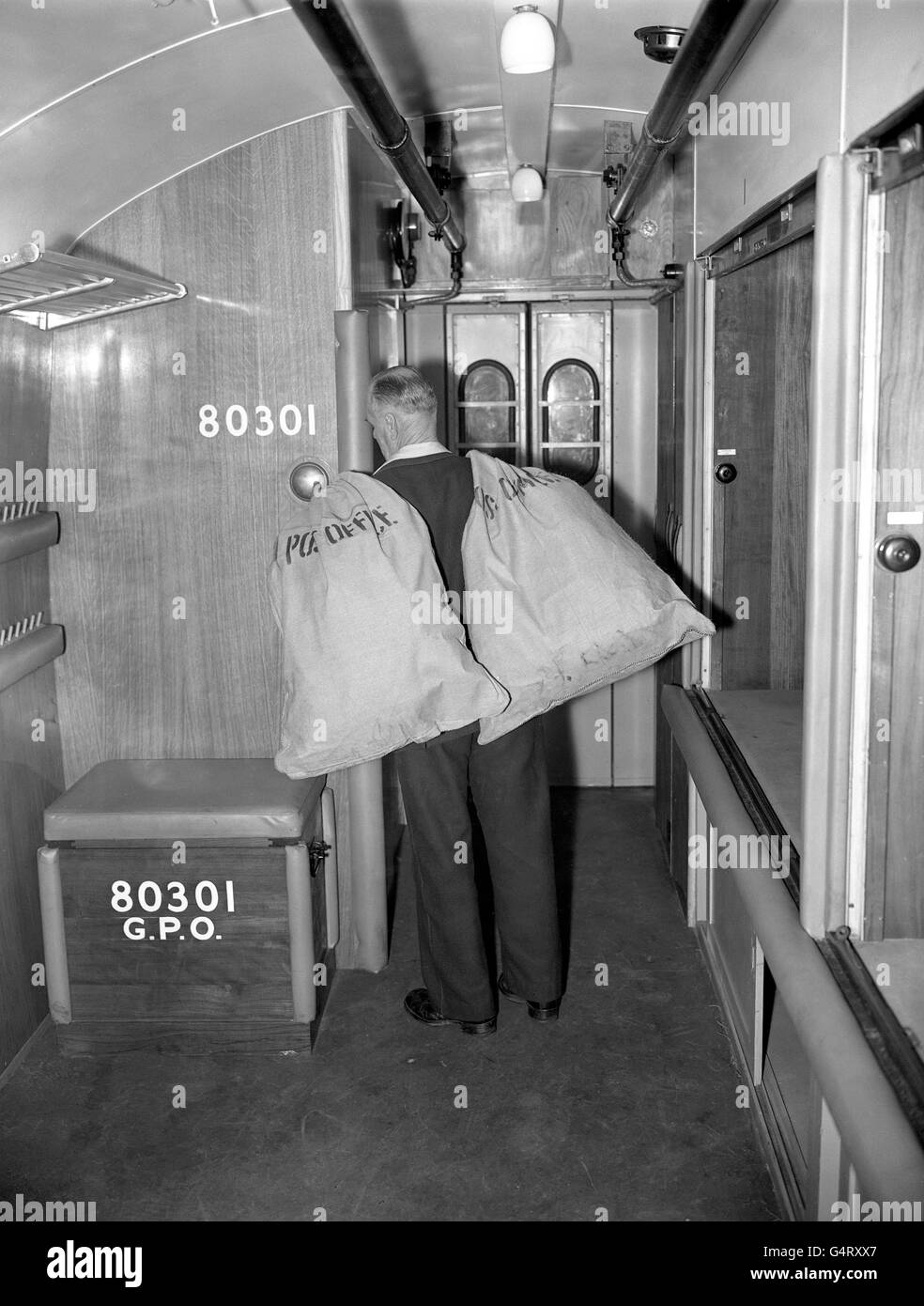 Un lavoratore postale carico di sacchi postali sul nuovo 'Great Western Travelling Post Office', un treno speciale per la smistamento della posta per il Paese Occidentale. Il nuovo treno servirà Buckinghamshire, Bedfordshire, Oxfordshire, Somerset e Gloucestershire Foto Stock