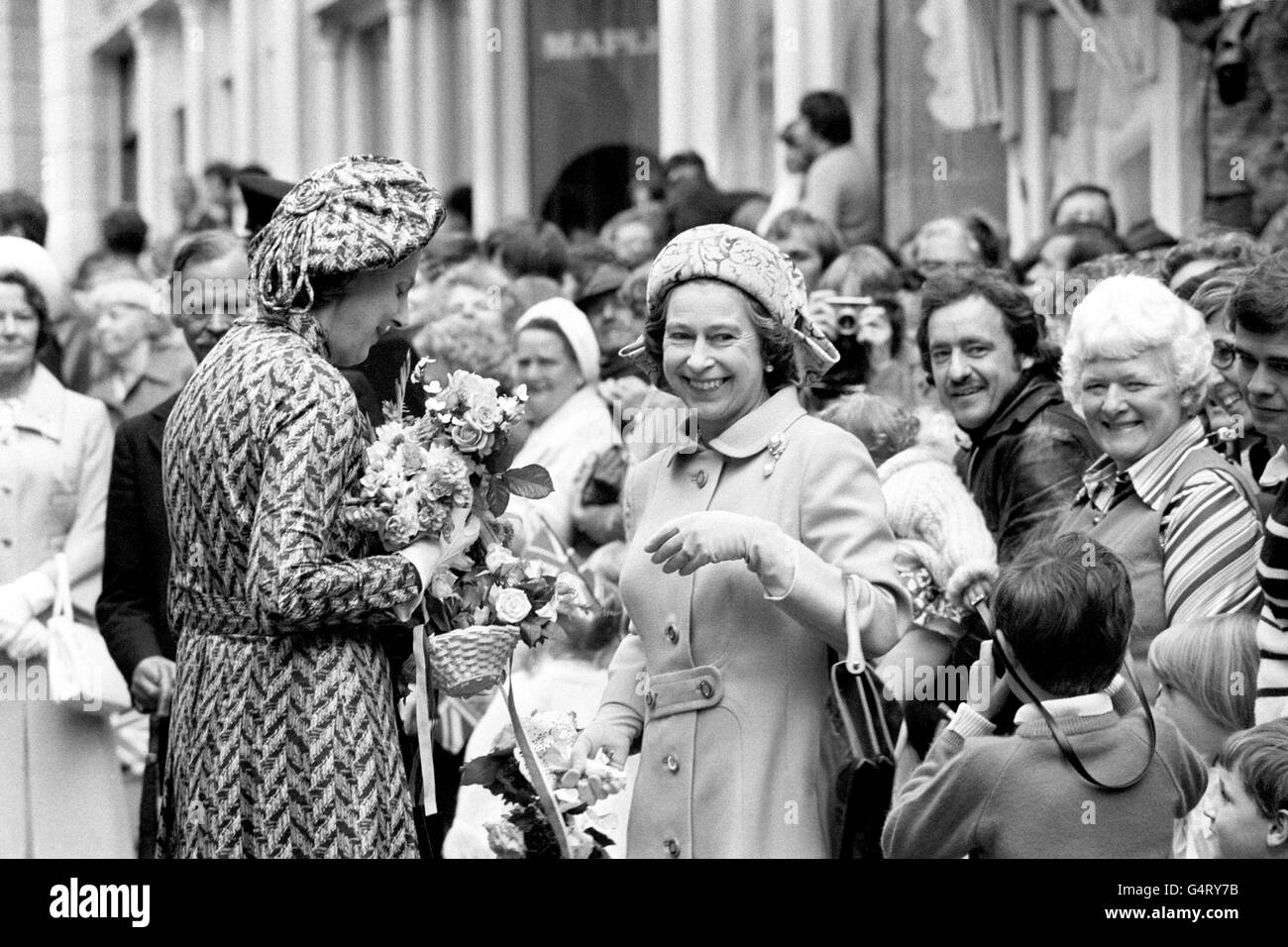 La Regina Elisabetta II consegna le posies alla Signora in attesa, la Duchessa di Grafton, e posa per una fotografia, in una passeggiata nel Porto di San Pietro, durante la sua visita all'isola di Guernsey, Isole del canale. Foto Stock