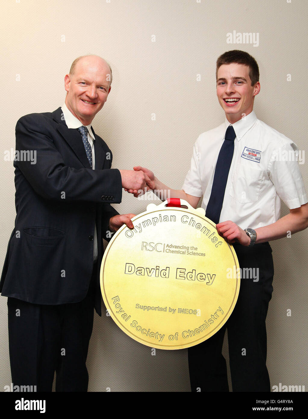 Il ministro della Scienza David Willetts (a sinistra) presenta il chimico olimpico David Edey con il suo Gold Medal Award per aver vinto il primo premio alla 43° Olympiad internazionale di chimica presso il Dipartimento di Affari, innovazione e competenze di Londra. Foto Stock