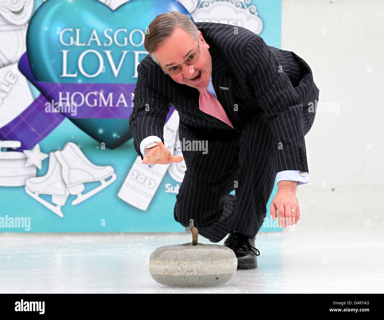 Gordon Matheson, leader del consiglio comunale di Glasgow, prova a curling al lancio delle celebrazioni "Hogmanayday" di Glasgow, una parte delle quali permetterà a tutti di provare a curling sulla pista di ghiaccio George Square di questo Hogmanay. Foto Stock