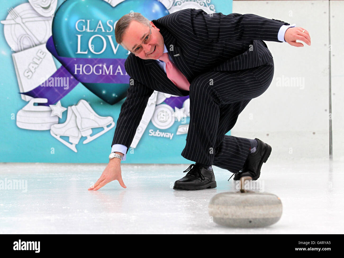 Gordon Matheson, leader del consiglio comunale di Glasgow, prova a curling al lancio delle celebrazioni "Hogmanayday" di Glasgow, una parte delle quali permetterà a tutti di provare a curling sulla pista di ghiaccio George Square di questo Hogmanay. Foto Stock