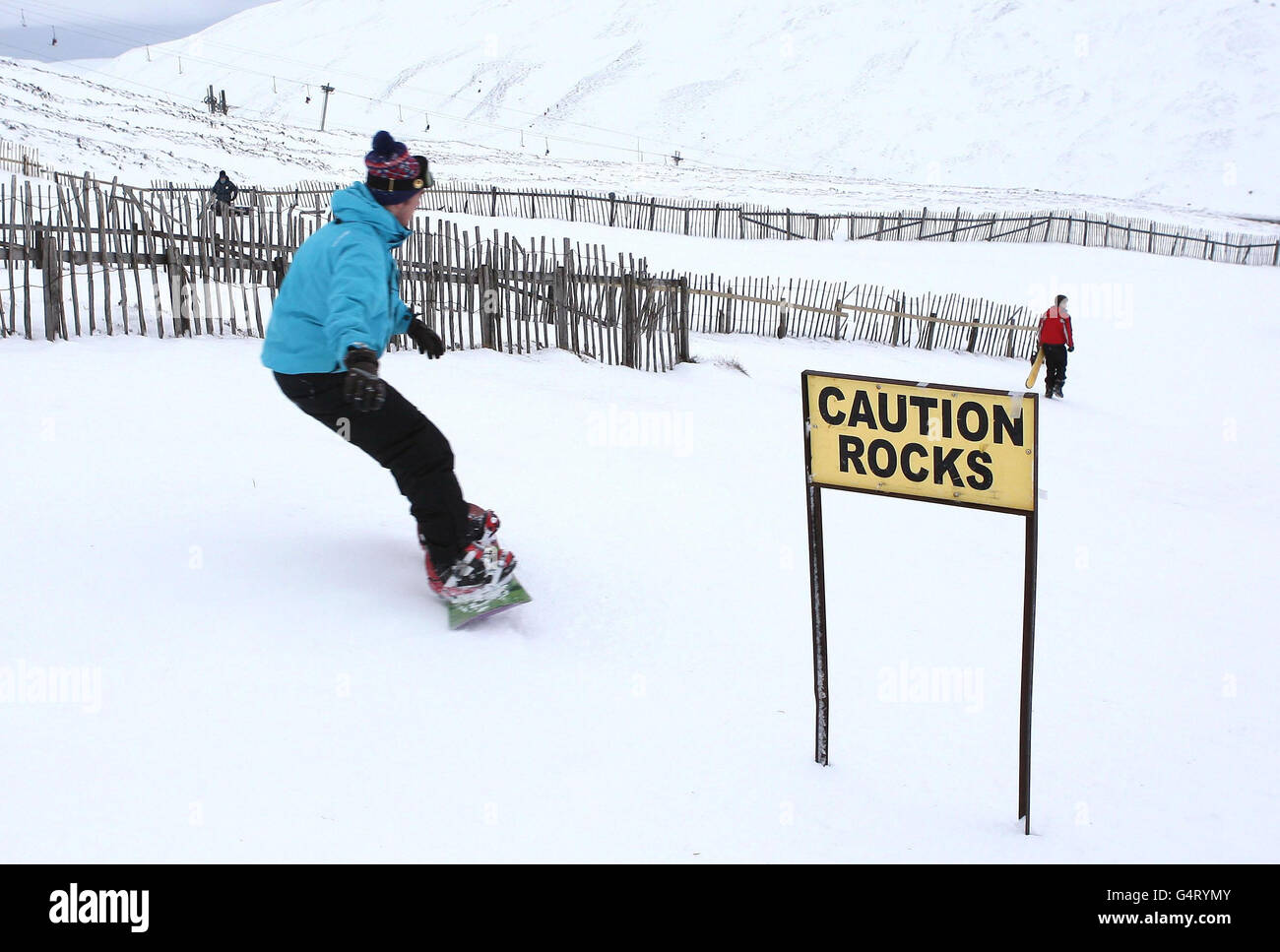 Un snowboarder porta alle piste mentre la stagione sciistica scozzese inizia a Glenshee vicino a Bramar, Scozia. Foto Stock