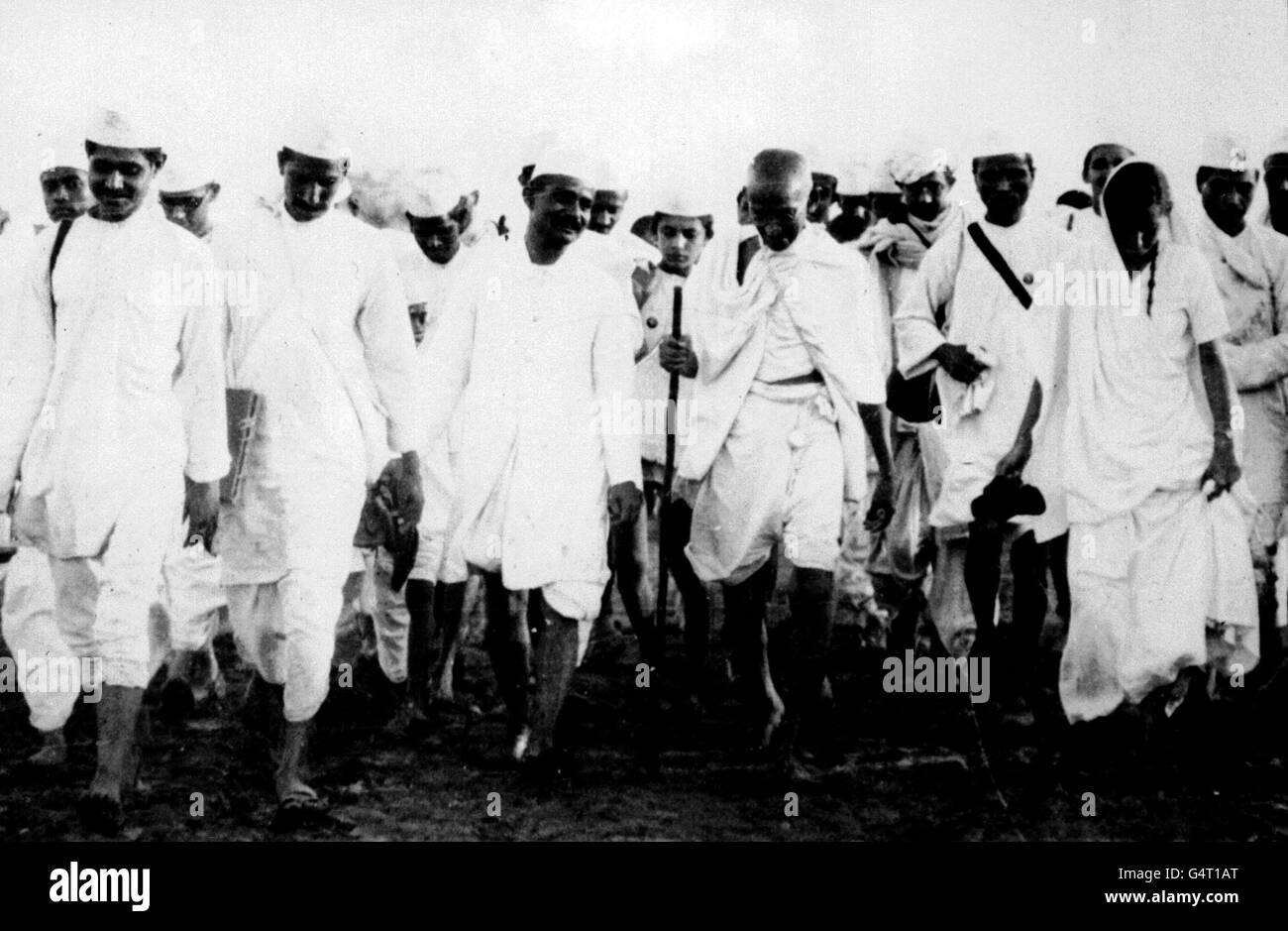 16 APRILE 1930: IL RAJ BRITANNICO. Mahatma Gandhi (centro, con il personale) con i suoi seguaci in viaggio per Dandi, vicino Bombay, per rompere le leggi del sale come parte della campagna di disobbedienza civile contro il Raj britannico. La produzione di sale era un monopolio statale strettamente controllato. Foto Stock