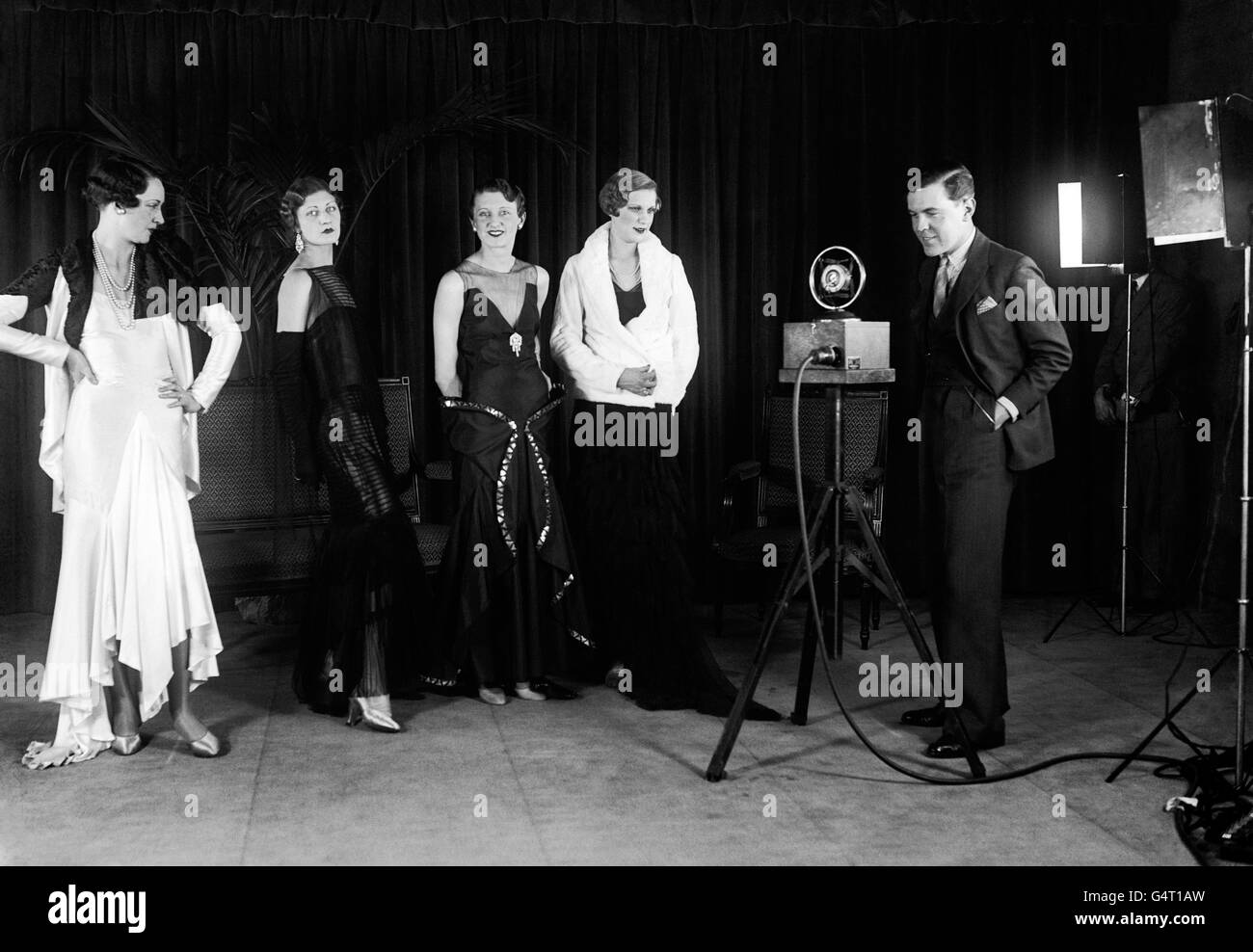 Norman Hartnell, il famoso giovane designer di abiti inglese, sta portando a Parigi alcuni dei suoi ultimi modelli britannici per competere con i designer francesi. Nella foto il signor Hartnell sta descrivendo i suoi modelli mentre è stato girato per Movietone News. Foto Stock