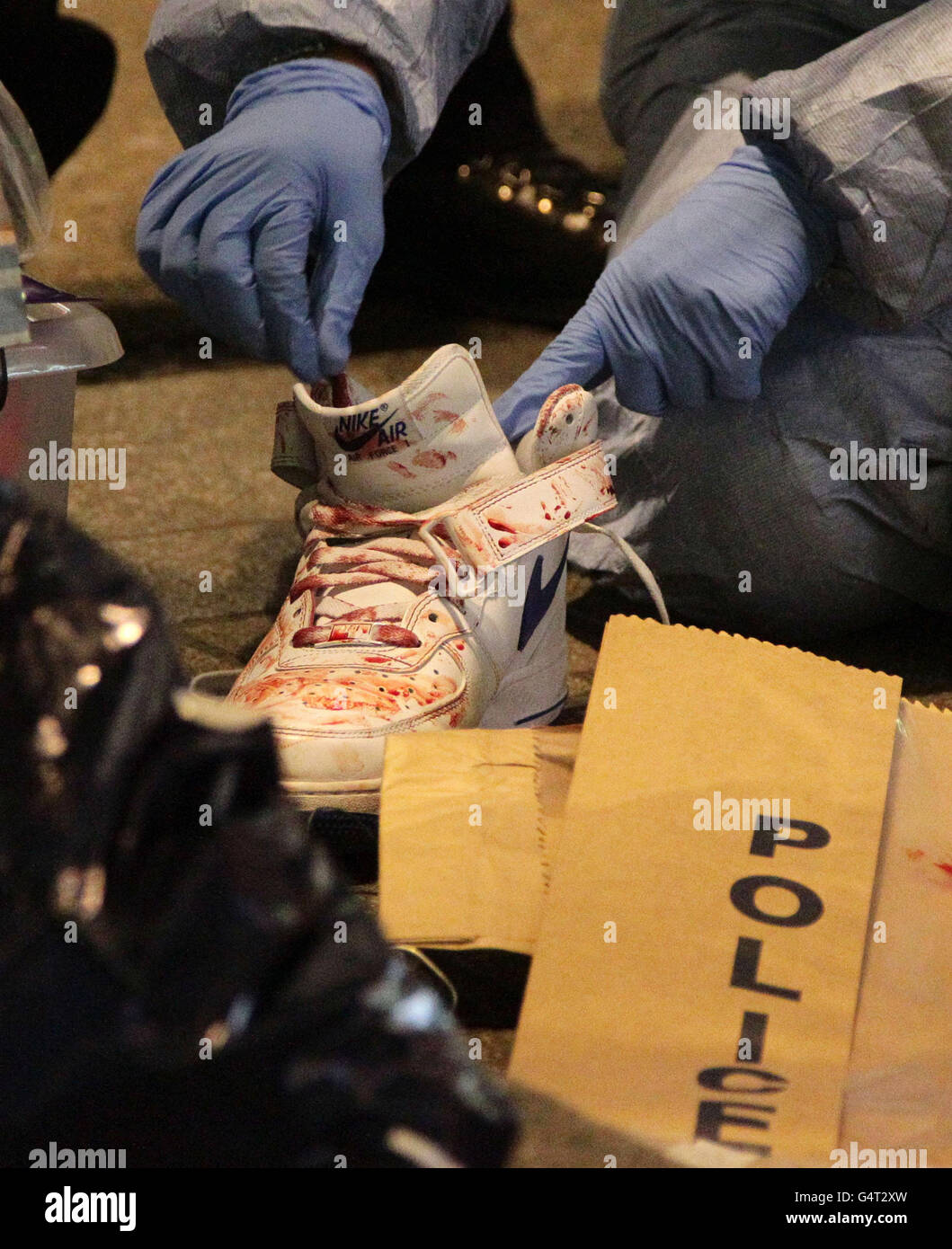 La polizia forense esamina un addestratore macchiato di sangue sulla scena di un secondo pugnale vicino all'incrocio di Oxford Street e Regent Street nel centro di Londra. Foto Stock