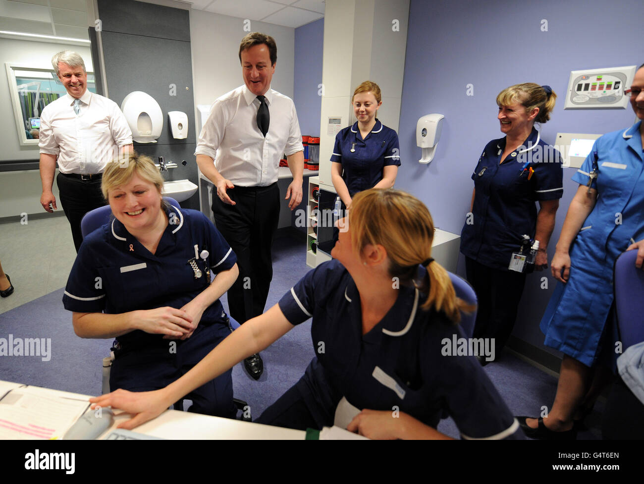 Il primo Ministro David Cameron e il Segretario di Stato per la Salute Andrew Lansley (a sinistra) incontrano le infermiere durante una visita al Royal Salford Hospital di Manchester. Foto Stock