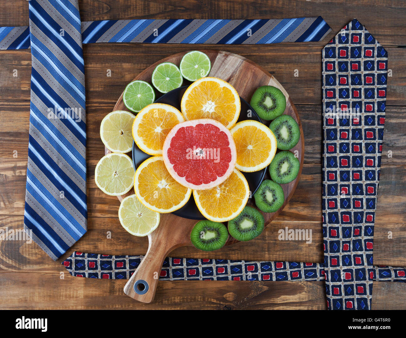 Un sano business lunch concetto con cravatte e fette di agrumi sul tagliere Foto Stock