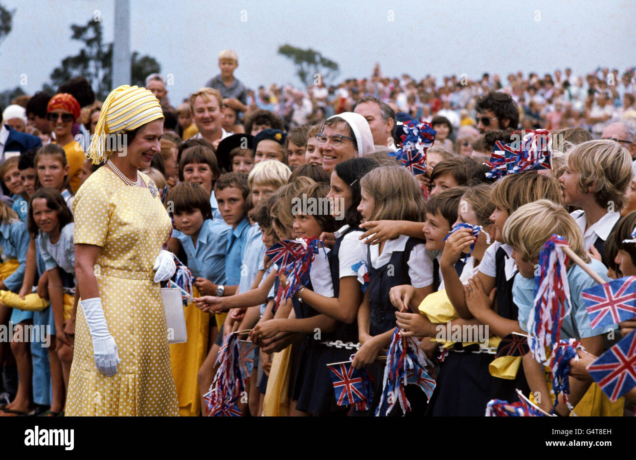 La Regina incontra i bambini delle scuole che sventolano la bandiera all'arrivo a Brisbane, durante il suo Silver Jubilee Tour of Australia. Foto Stock