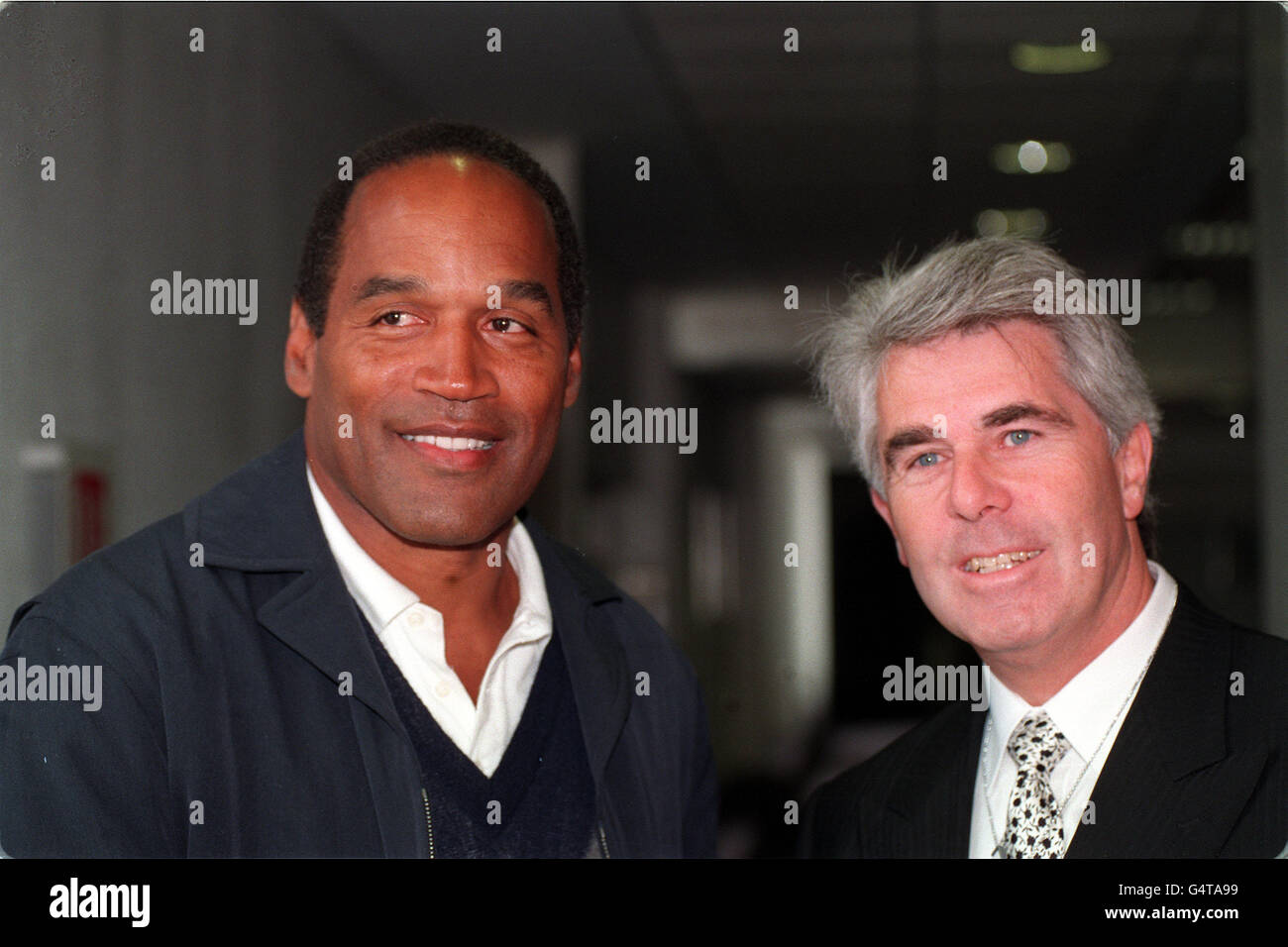 OJ Simpson con il pubblicista Max Clifford all'aeroporto di Heathrow al suo arrivo nel Regno Unito. Foto Stock