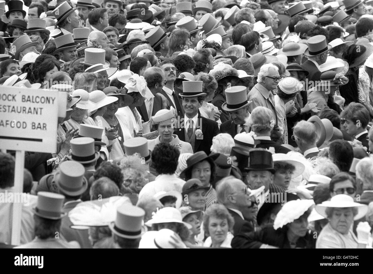 La regina Elisabetta II è circondata da un mare di volti quando arriva a Royal Ascot. Dietro di lei, a sinistra, sorridendo con il cappello superiore è il sovrintendente capo Jim Beaton, l'ufficiale della polizia della regina. Foto Stock
