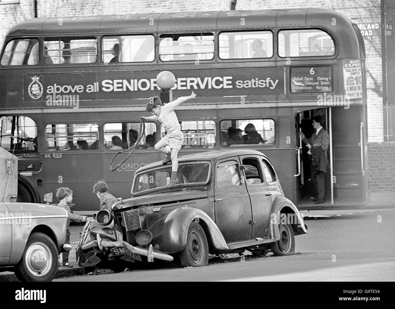 I bambini si divertono su un'auto rottamata nella zona di Hampstead a Londra. Foto Stock