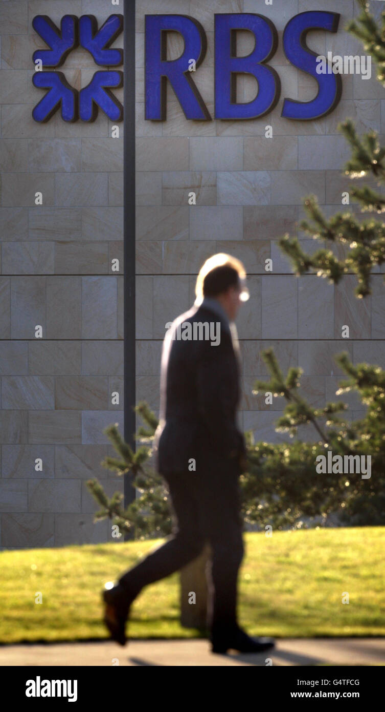 Un uomo passa accanto a un cartello RBS presso la sede centrale della Royal Bank of Scotland a Gogarburn in Scozia. Foto Stock