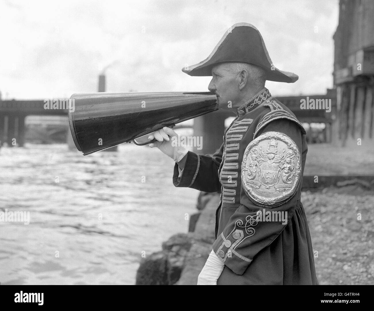 Harry Phelps, Bargemaster alla Fishmongers Company e assistito da un megaphone dà istruzioni ai concorrenti nella 245a Doggett's Coat e Badge Race. Il Goggett's Coat and Badge è il premio e il nome della più antica gara di canottaggio del mondo Foto Stock